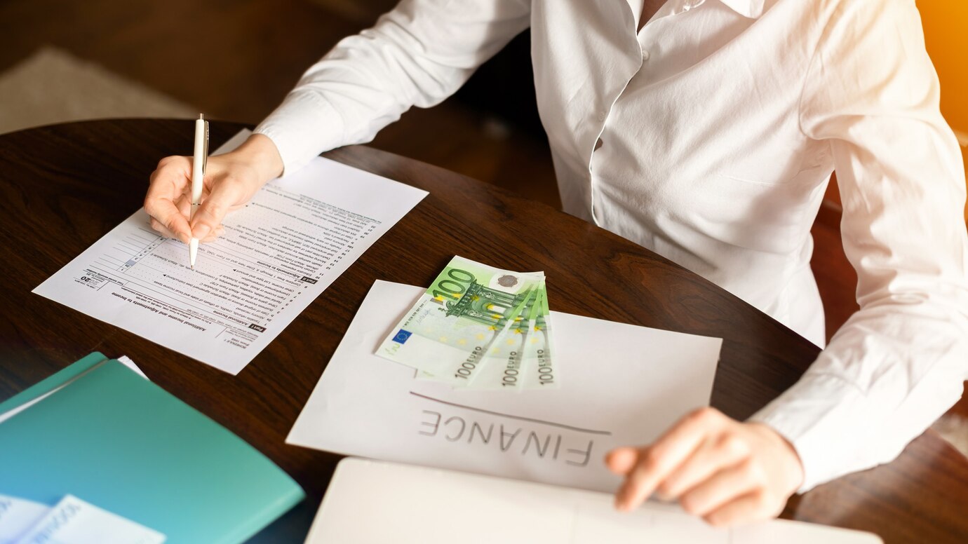 woman-working-with-finances-table-money-papers_1268-17475